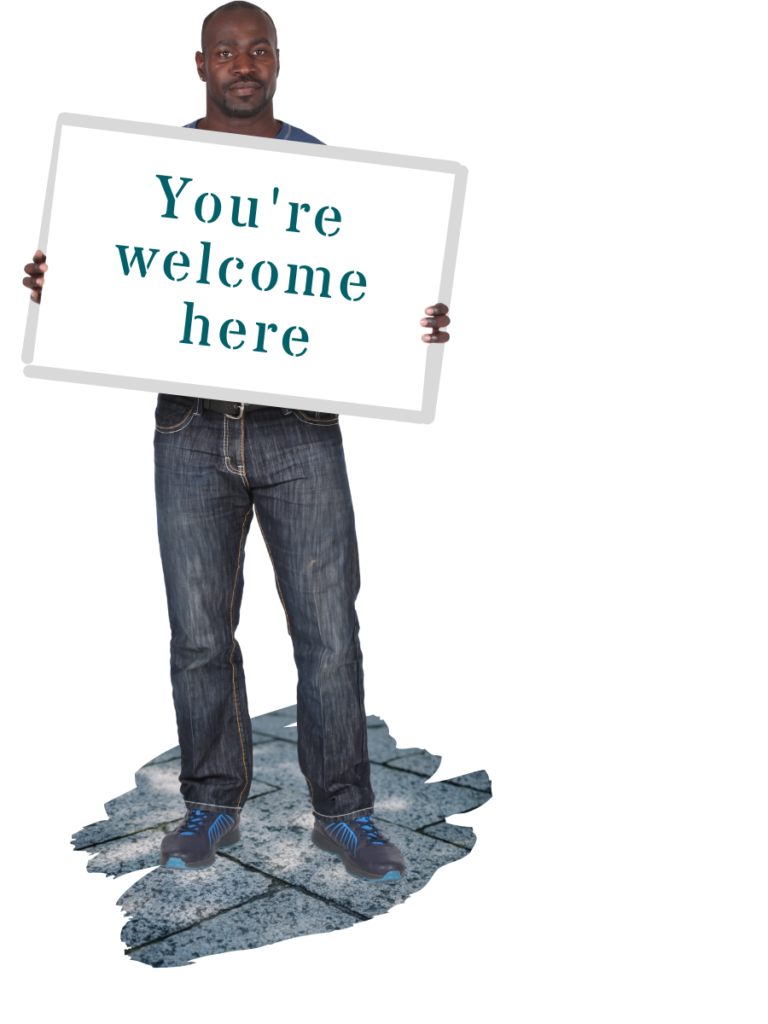 A man holding a placard stating You're welcome here